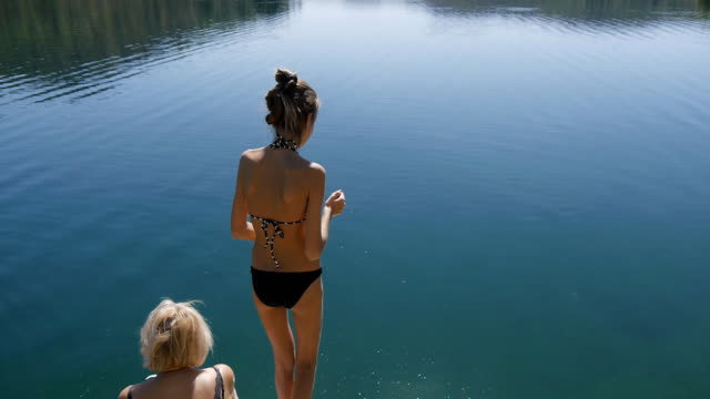 Schlanke-Mädchen-ins-Wasser-des-Sees-springen