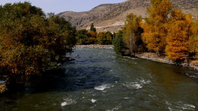 Ein-Fluss-fließt-über-Felsen-in-diese-wunderschöne-Szene-im-Herbst