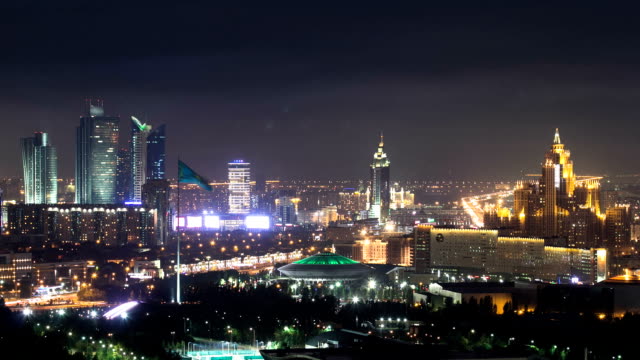 Vista-de-noche-elevado-sobre-el-centro-de-la-ciudad-y-el-distrito-central-de-negocios-con-circo-Timelapse,-Kazajstán,-Astana