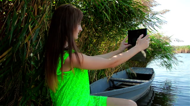 Young-woman-in-green-dress-makes-selfi-for-upgrade-profiled-in-social-networks