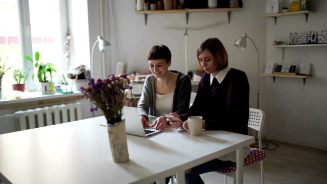 Zwei-Studenten-der-Frau-am-Tisch-mit-Notebook-für-Online-Lernen-im-Hause