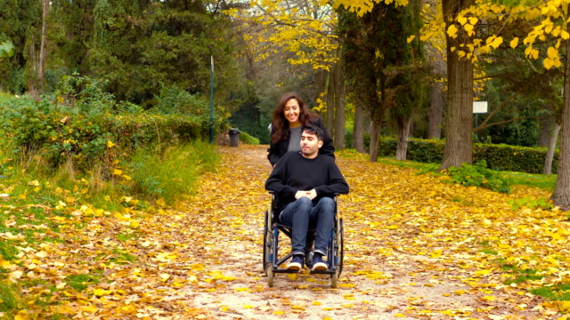 Behinderung,-Liebe,-Romantik---Mann-im-Rollstuhl-in-den-Park-mit-seiner-Freundin