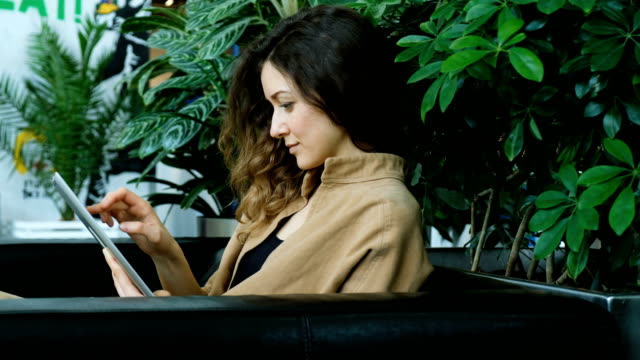 Businesswoman-uses-a-tablet-in-the-business-center