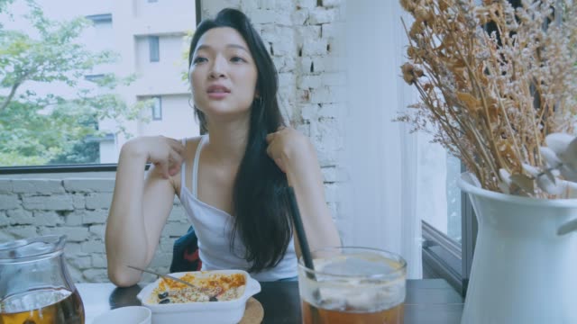 Schöne-asiatische-Mädchen-chatten-mit-Freunden-zur-Mittagszeit