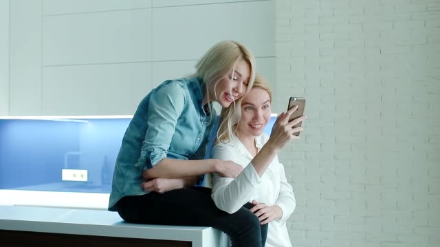 Zwei-Frauen,-die-Fotos-auf-dem-Smartphone-ansehen