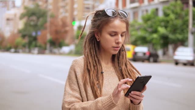 Hipster-Mädchen-messaging-auf-mobile-im-freien