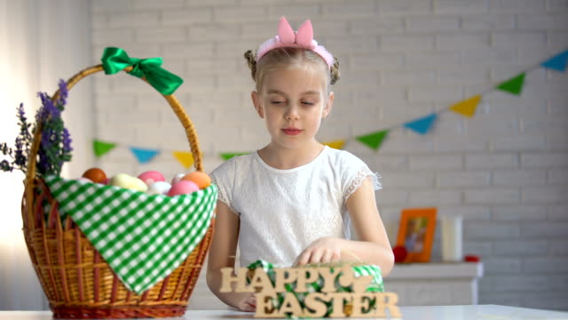 Female-kid-counting-colored-eggs-and-putting-in-basket,-happy-Easter-greeting