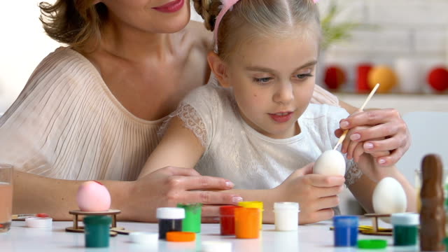 Amorosa-madre-enseñanza-hija-zurda-para-decorar-huevos-de-Pascua-con-pintura