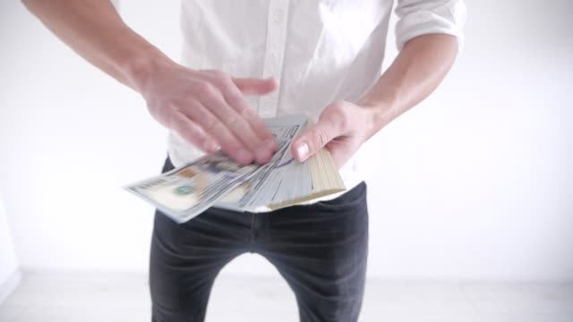 Rich-Businessman-throwing-money-on-a-white-background.-Slow-motion