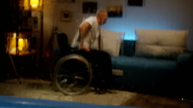 Hombre-discapacitado-transfiriendo-de-silla-de-ruedas-a-sofá