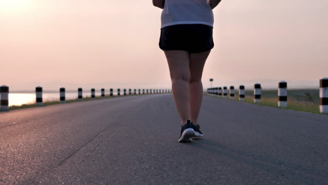 Mujeres-asiáticas-con-sobrepeso-corriendo-en-la-calle-en-la-luz-del-sol-temprano-por-la-mañana.-concepto-de-perder-peso-con-ejercicio-para-la-salud.-Cámara-lenta,-vista-inferior