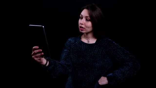 Nahaufnahme-Porträt-von-Erwachsenen-schöne-kaukasische-Brünette-Frau-mit-einem-Videoanruf-auf-dem-Tablet-mit-Hintergrund-isoliert-auf-schwarz