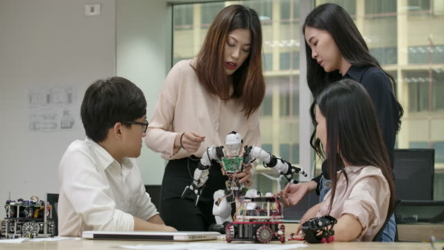 Junge-asiatische-Kreative-Treffen,-Programmierung-für-kollaborative-universelle-Robotik-am-Laptop-in-der-Werkstatt.-Menschen-mit-Technologie--oder-Innovationskonzept.