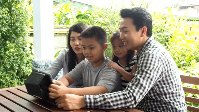 asia-familia-buscando-tableta-feliz-juntos