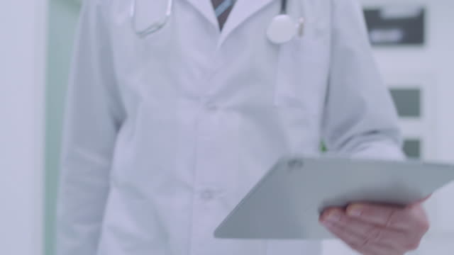 Male-doctor-with-tablet-shaking-hand-of-female-colleague-in-hospital,-team-work