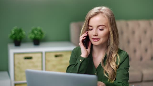 Geschäftsfrau-sprechen-verwenden-Smartphone-Arbeit-zu-Hause-mit-Laptop.-Mittlere-Nahaufnahme-auf-4k-RED-Kamera