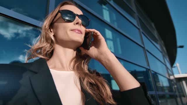 Angenehme-Business-weibliche-sprechen-verwenden-Smartphone-in-der-modernen-Innenstadt.-4k-Dragon-RED-Kamera