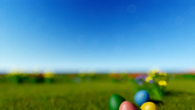 Easter-eggs-on-green-meadow-over-blue-blurry-sky,-tilt