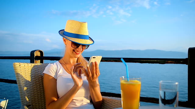 Glückliches-Mädchen-kommuniziert-in-sozialen-Netzwerken-per-Handy-in-einem-café