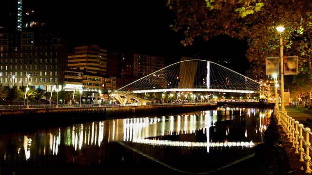 Night-view-at-arch-footbridge-across-Nervion-River-in-Bilbao,-Spain,-timelapse
