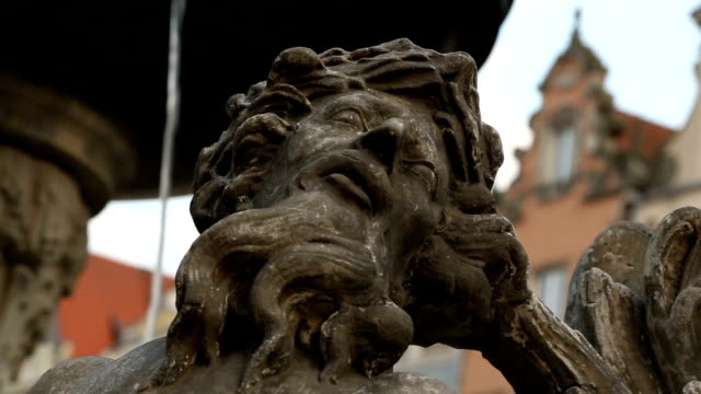 Brunnen-mit-alten-Skulpturen-gegen-Stadtplatz,-historische-Innenstadt,-Tourismus