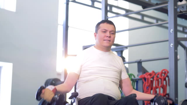 Man-in-a-wheelchair-trying-to-overcome-muscles-weakness.