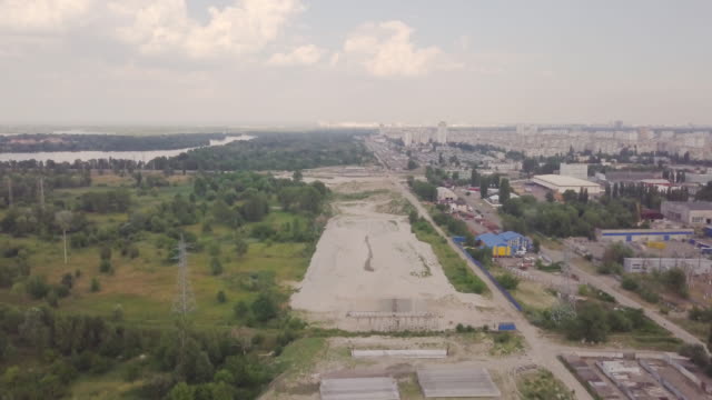 Construction-of-a-bypass-road-for-transport-near-the-outskirts-of-the-city.-Construction-site.-Aerial-view.-The-city's-line-with-nature-and-buildings