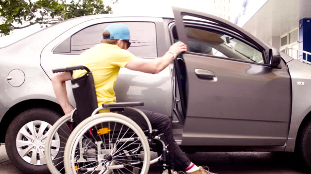 Un-hombre-en-una-silla-de-ruedas-y-una-mujer-cerca-del-coche