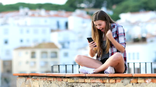 Aufgeregt-Teen-Suche-nach-Online-Inhalten-auf-einem-Telefon