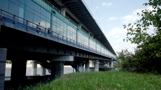 Panorama-of-a-glass-bridge-with-a-passing-train-inside