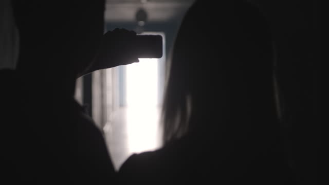 Silhouetten-von-Mann-und-Frau-unter-Selfie-mit-Telefon-im-Flur