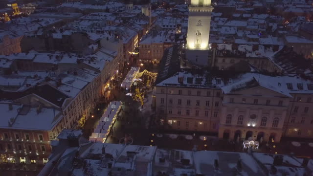 Lviv,-Ukraine---25,-December-2018.-Arial-shot.-Winter.-Rynok-square-street.-Christmas-Fair.-Lvov-Town-Hall,-City-Council.-People-are-walking-in-the-city-center.-Christmas-decorations-and-lights.-Night-time