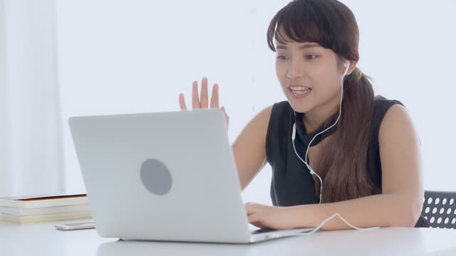 Beautiful-young-asian-woman-smiling-say-hello-using-chat-social-network-with-video-call-on-laptop-computer,-teen-girl-relax-enjoy-communication-and-lifestyle-concept.
