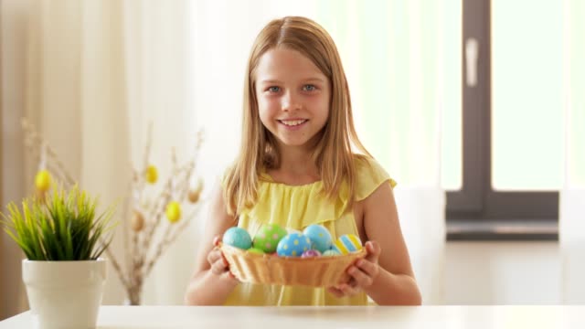 Chica-feliz-mostrando-color-huevo-de-Pascua-en-casa