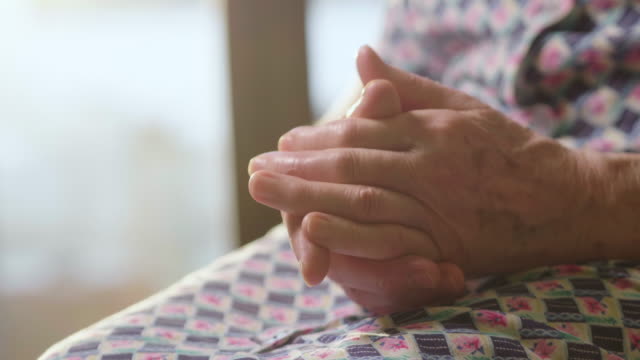 cinematic-hands-of-an-elderly-woman-who-pray-in-faith-in-the-name-of-our-lord