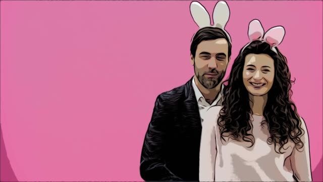 Young-creative-couple-on-pink-background.-With-hackneyed-ears-on-the-head.-During-this-time,-they-show-the-gestures-of-the-call-and-look-at-the-other-side-together.-Easter.