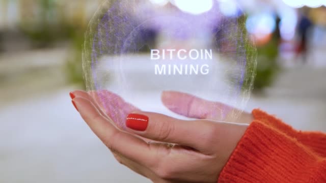 Female-hands-holding-hologram-Bitcoin-Mining