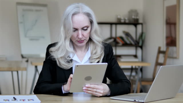 Vieja-mujer-de-negocios-usando-la-tableta