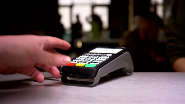Nahaufnahme-der-Person-streift-Kreditkarte-durch-Terminal-Maschine-die-Zahlung.