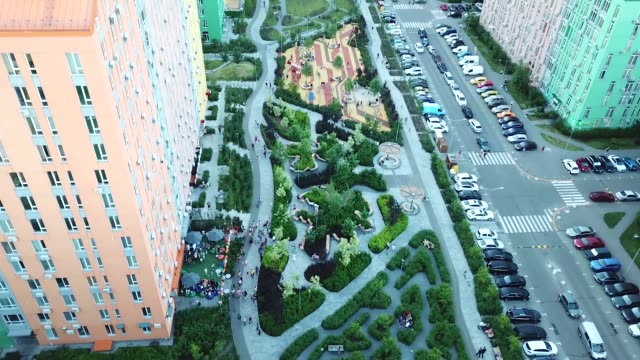 Drohne-erhebt-sich-über-einem-schönen-Park-in-einem-Wohngebiet-mit-bunten-Häusern