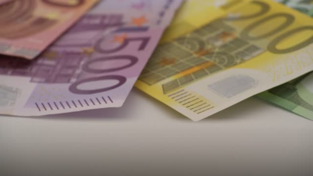 4K-Primer-plano-de-una-moneda-de-un-euro-con-billetes-de-diferentes-valores.-Dinero-en-efectivo