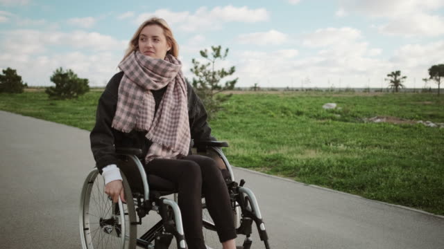 Einsame-behinderte-Frau-im-Rollstuhl-im-Freien