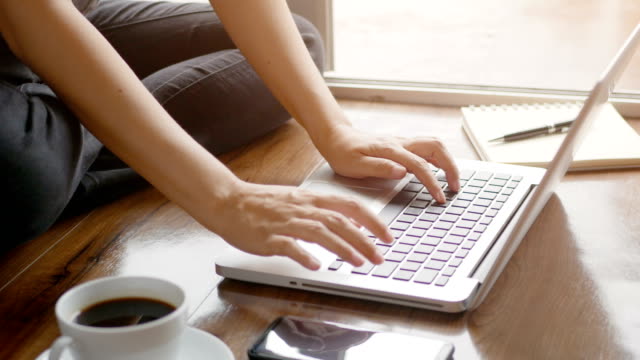 4K.-Frau-Hand-eingabeende-auf-Notebook-Computer-Laptop-Tastatur-für-die-Arbeit-auf-dem-Boden-zu-Hause-mit-entspannenden