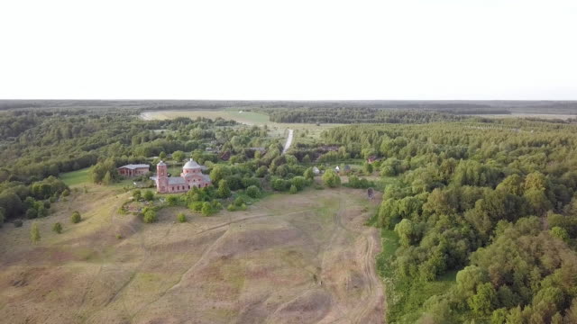 Aerial-view-of-the-Russian-forest,-river-and-steppe-overlooking-an-abandoned-Church-and-architectural-objects