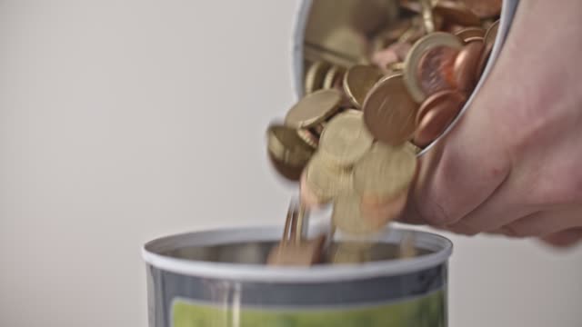 Pouring-euro-coins-into-a-jar-close-up