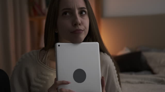 Nachdenkliche-teen-Mädchen-mit-digitalen-Tablet-zu-Hause
