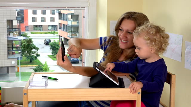 Mutter-mit-Kind-schießen-Selfie-Fotos-mit-Smartphone.