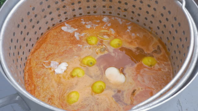 Mann-fällt-Zwiebeln-in-einen-großen-Topf-mit-würzige-Cajun-Brühe-auf-Langusten-Kochen