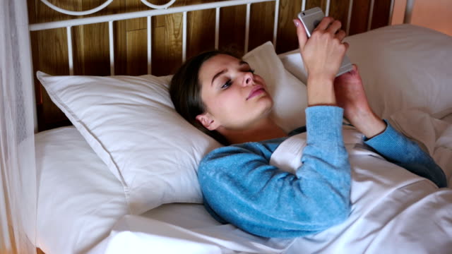 Frau-im-Bett-Surfen-auf-Smartphone-in-der-Nacht