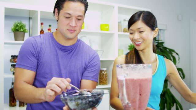 Young-Ethnic-couple-using-blender-organic-fruit-drink